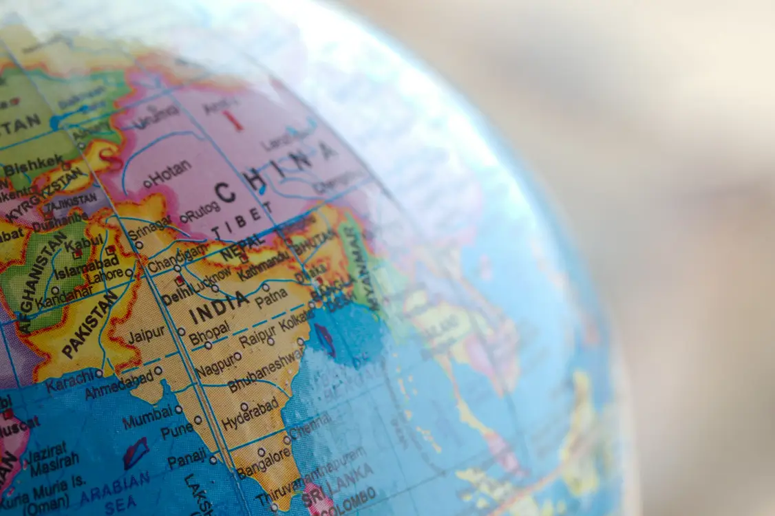 Close-up of a globe highlighting the countries of India, Pakistan, and surrounding regions in South Asia.